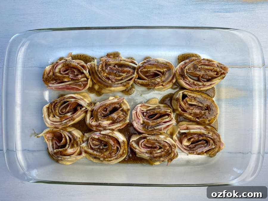 Ham and cheese roll-ups in baking dish with glazed on top