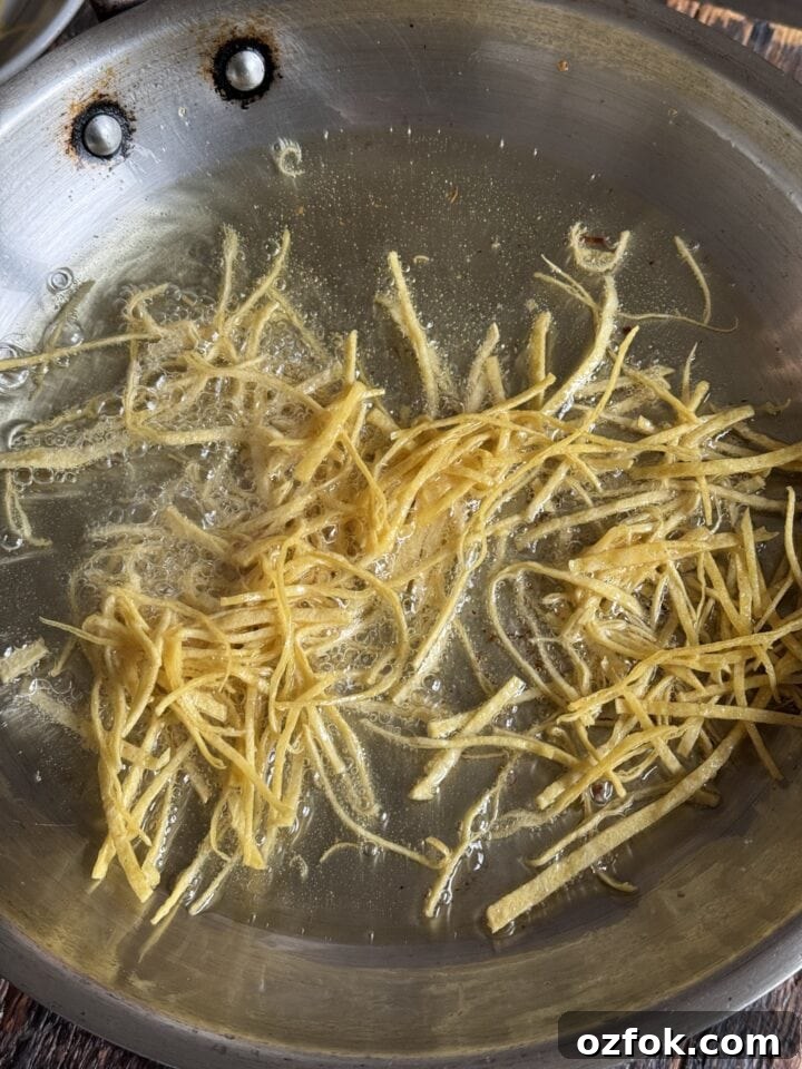 Spicy Chicken Soup Recipe: Flavorful Homemade Chicken Stew 11 a photo of tortilla strips frying in a pan