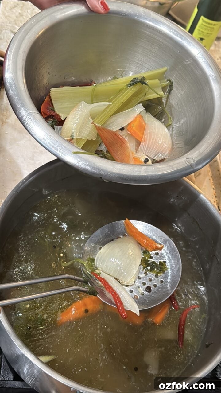 Spicy Chicken Soup Recipe: Flavorful Homemade Chicken Stew 6 a photo of teri straining the vegetables out of the spicy chicken stock