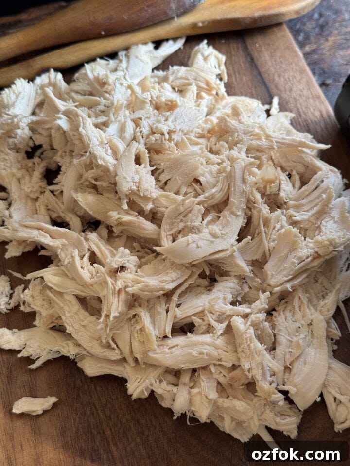 Spicy Chicken Soup Recipe: Flavorful Homemade Chicken Stew 7 a photo of pulled chicken on a cutting board