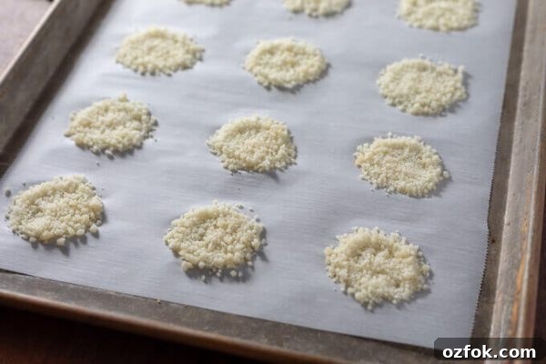 Keto Parmesan Crisps: Crispy Low-Carb Cheese Chips 3 Parmesan crisps on parchment lined baking sheet before baking.