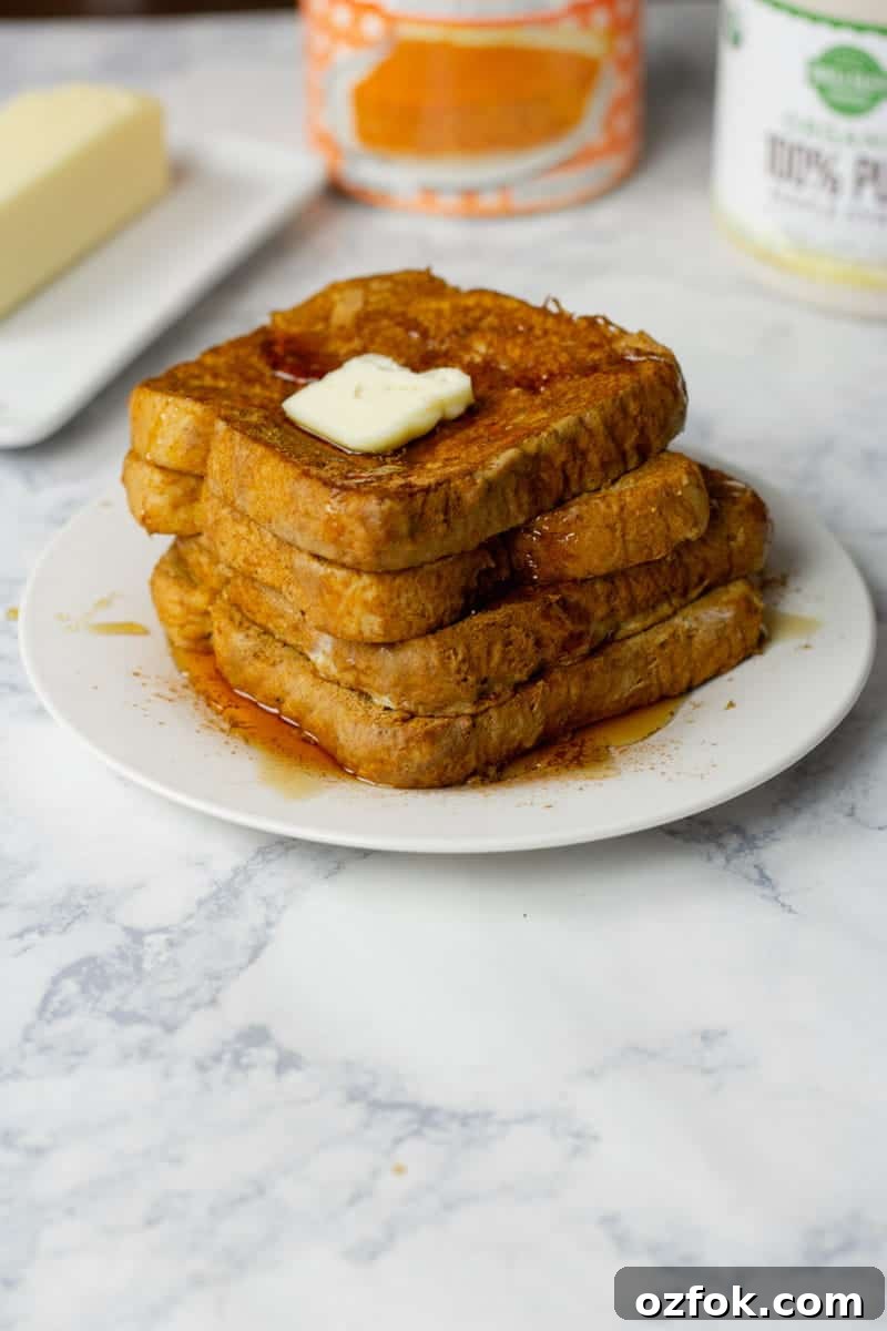 Pumpkin Spice French Toast Recipe for Fall Brunch 2 Pumpkin French Toast Recipe Stacked on White Plate with Butter and Syrup