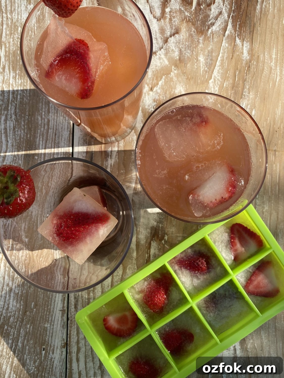 Strawberry lemonade in a glass with frozen strawberry cubes