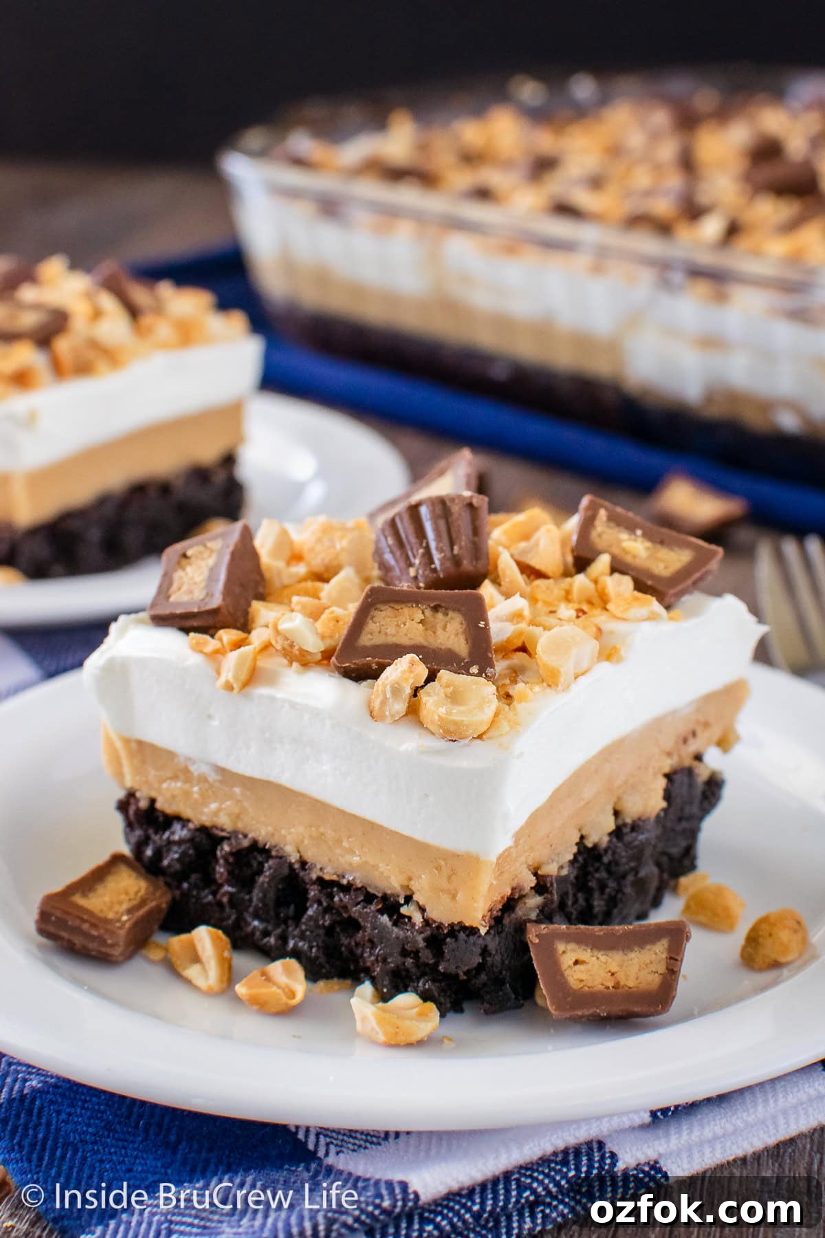 Peanut Butter Brownie Layered Dessert: Decadent No-Bake Treat 2 A layered brownie dessert with peanut butter on a white plate.