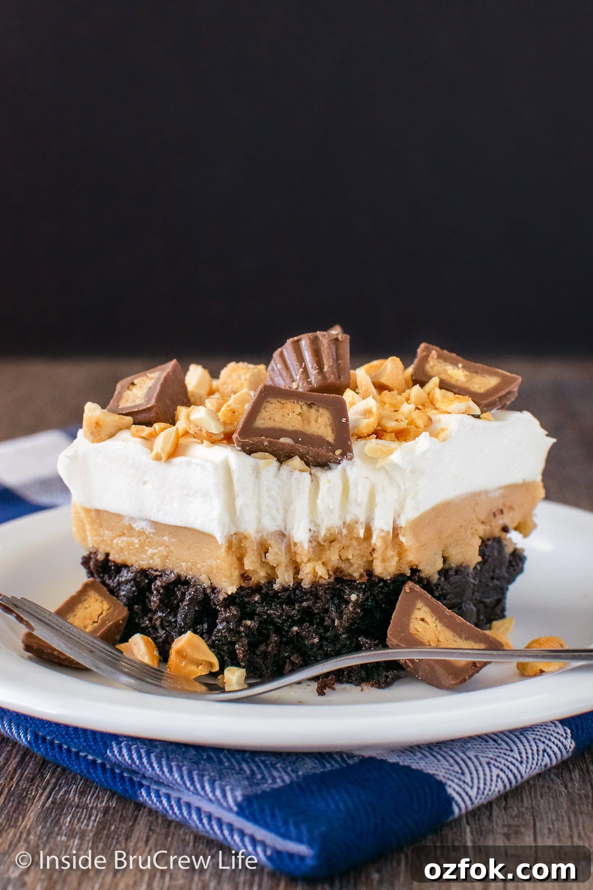 Peanut Butter Brownie Layered Dessert: Decadent No-Bake Treat 3 A square of layered brownie dessert on a white plate.
