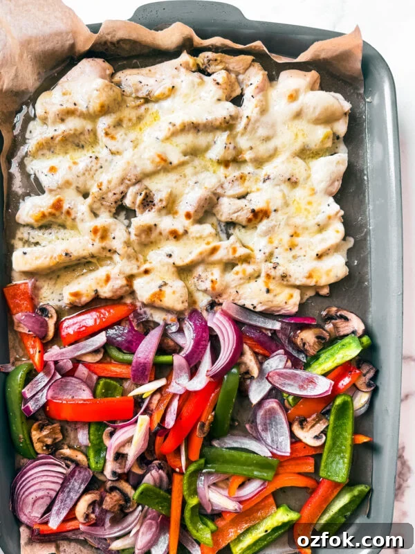 Greek Sheet-Pan Chicken with Tangy Feta and Roasted Veggies 14 Sheet pan with veggies and cheesy chicken morsels.