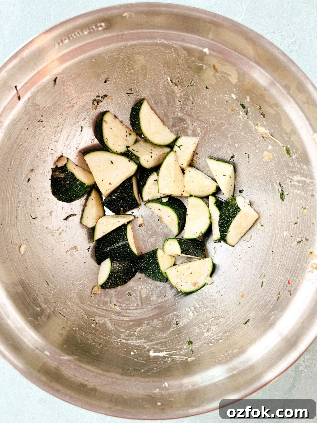 Greek Sheet-Pan Chicken with Tangy Feta and Roasted Veggies 7 Chopped zucchini in a mixing bowl.