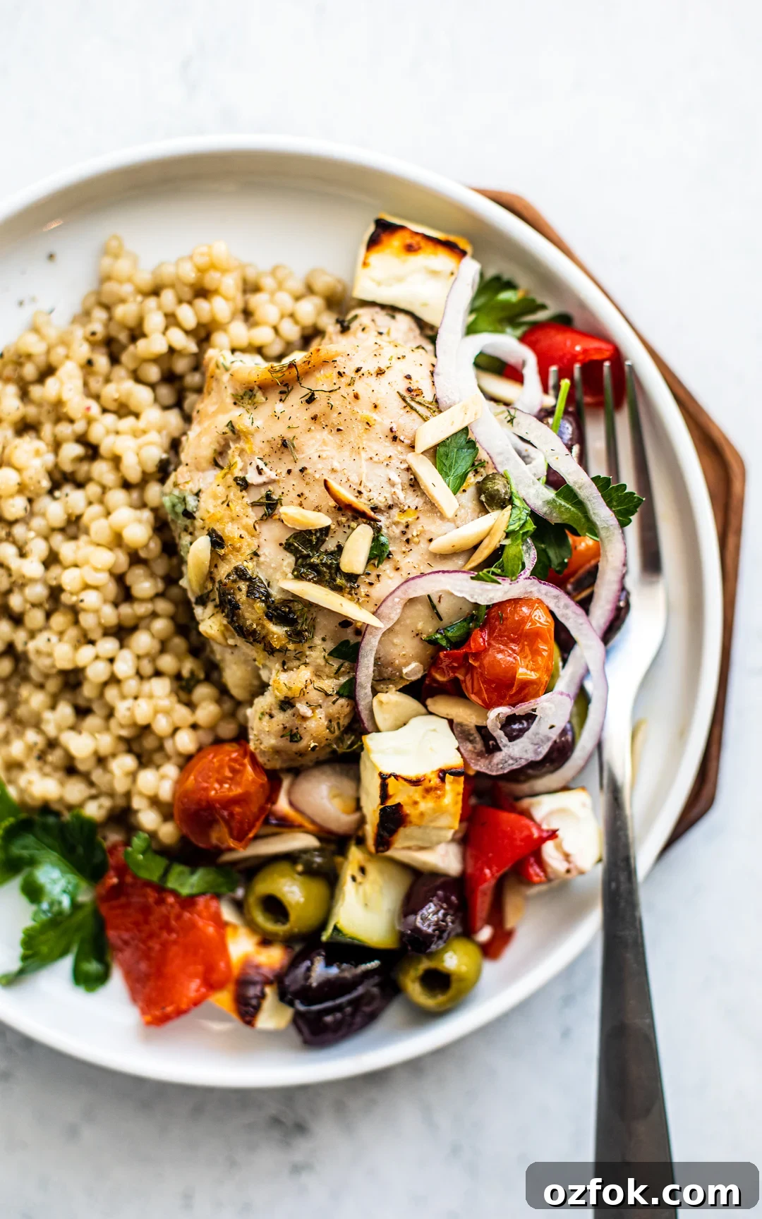 Greek Sheet-Pan Chicken with Tangy Feta and Roasted Veggies 10 Overhead shot of plate with couscous and Greek chicken with vegetables.