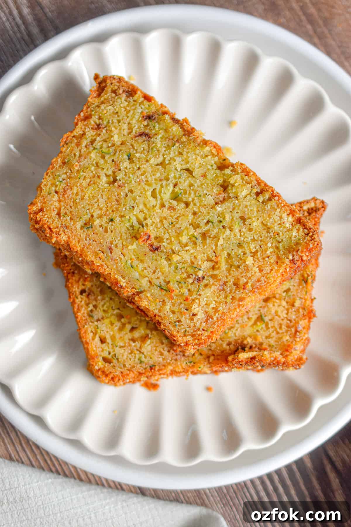 Moist Zucchini Bread Made with Self-Rising Flour 2 Two slices of zucchini bread with self rising flour are on a fluted plate.