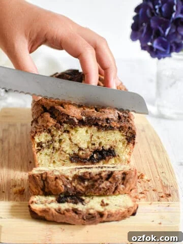A knife is cutting into the nutella zucchini bread