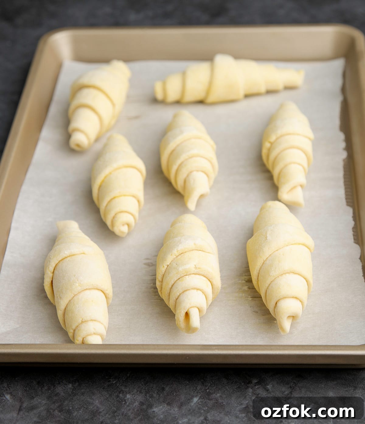 Flaky Gluten-Free Croissants: Buttery Recipe for Perfect Layers 4 8 raw gluten free croissants on white paper on baking tray