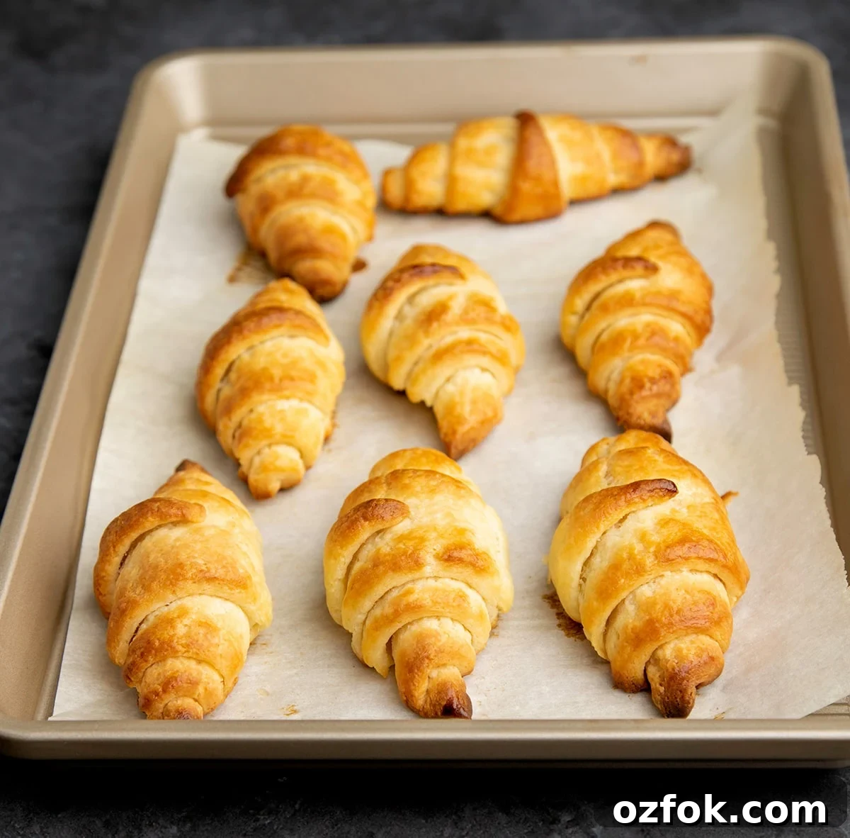 Flaky Gluten-Free Croissants: Buttery Recipe for Perfect Layers 5 8 baked gluten free croissants on white paper on tray