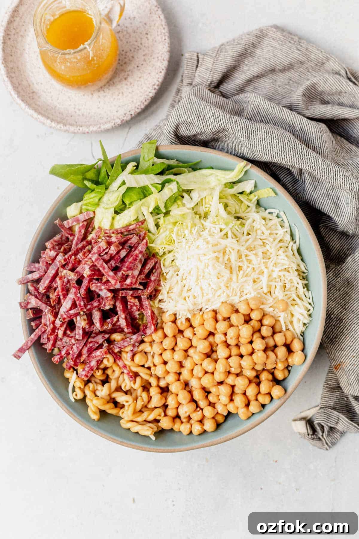 salami, lettuce, chickpeas, and shredded mozzarella on top of pasta