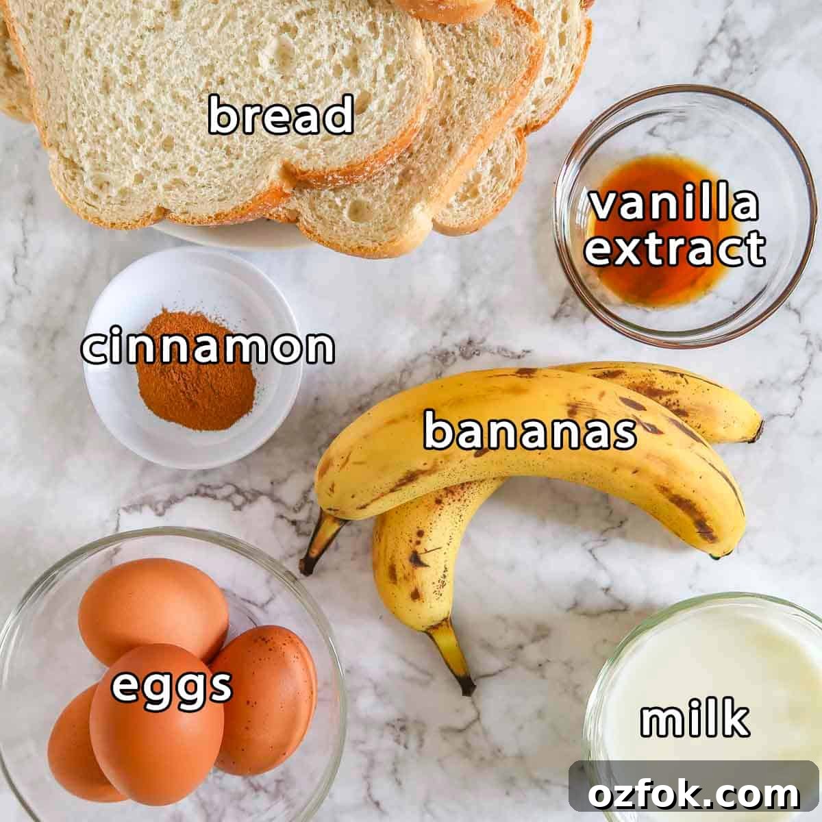 Overhead shot of ingredients - bread, vanilla extract, cinnamon, bananas, eggs, and milk.