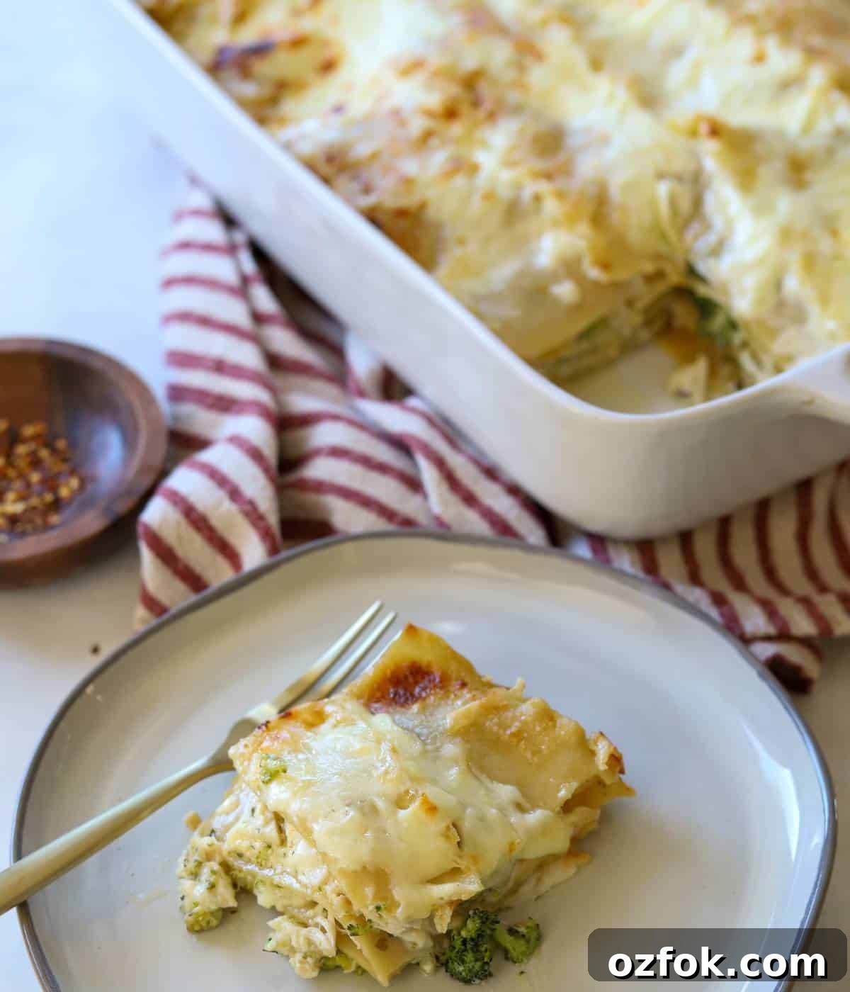 12 Quick Weeknight Dinners Made with Rotisserie Chicken 13 Chicken lasagna with broccoli sliced on plate.