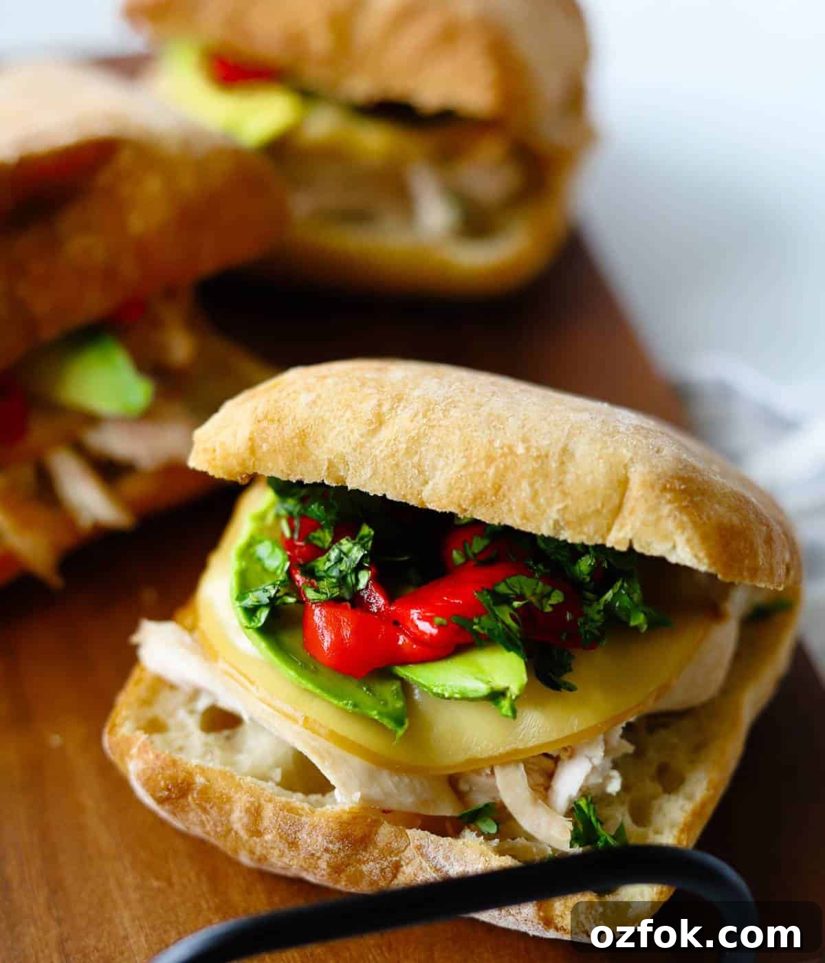 12 Quick Weeknight Dinners Made with Rotisserie Chicken 7 Chipotle chicken avocado melts on wooden platter.