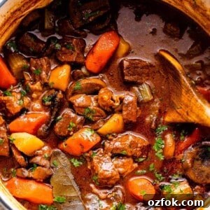 overhead shot of a white dutch oven filled with guinness beef stew.