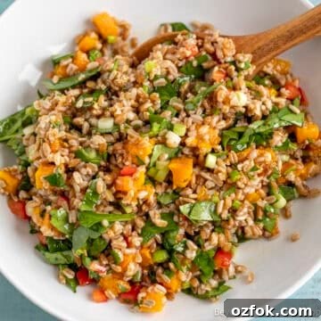 Farro Salad with roasted butternut squash and spinach in a white bowl.