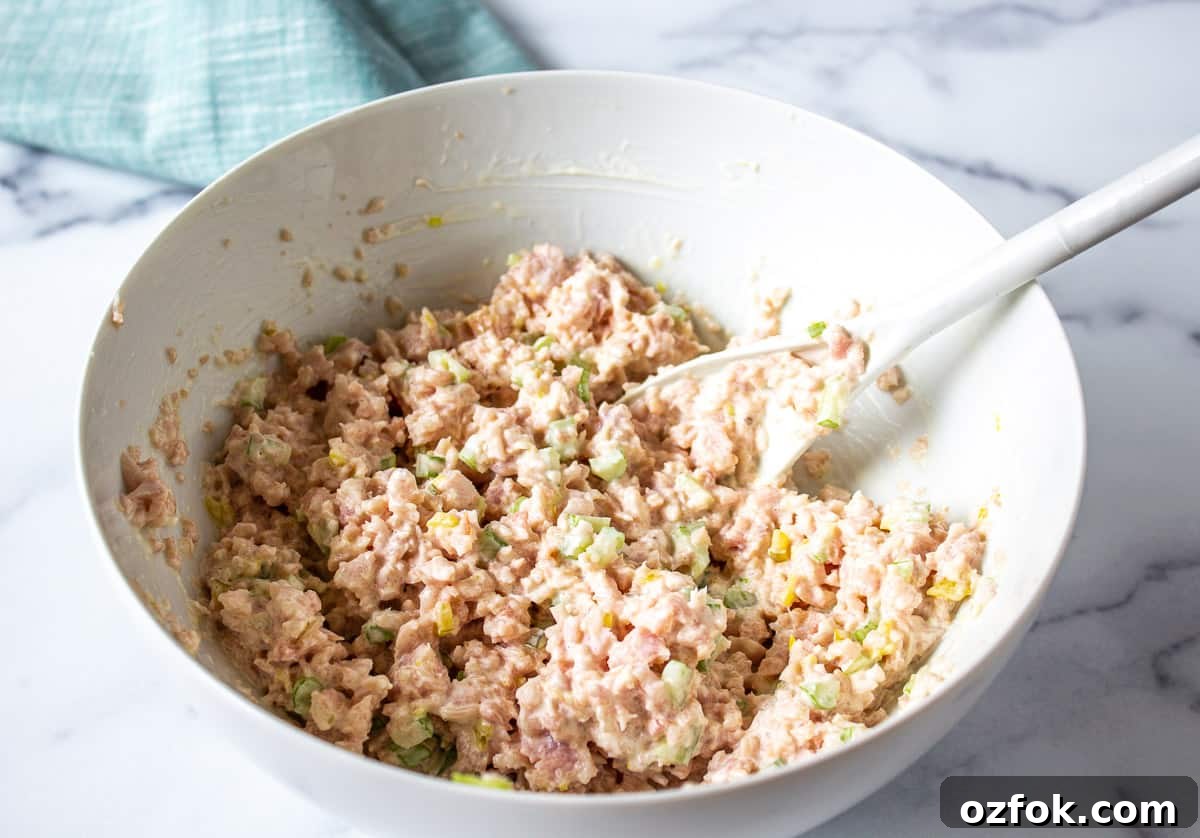 Classic Creamy Ham Salad Recipe for Sandwiches and Dips 6 Deviled ham salad in a white bowl with a mixing spoon.