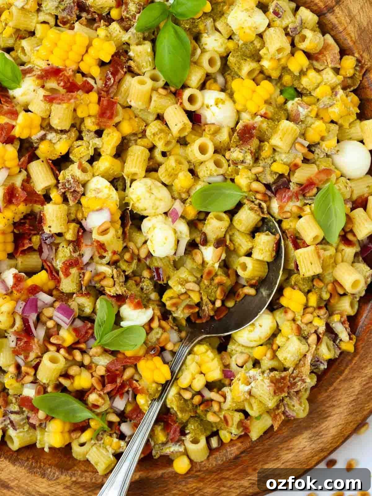 15-Minute Pesto Pasta Salad Recipe for Quick Weeknight Meals 2 A big bowl full of Pesto Pasta Salad, with a spoon about to serve.