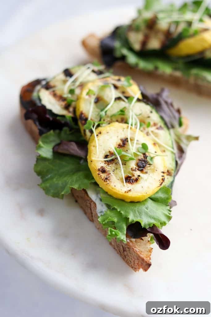 Grilled Summer Squash Smørrebrød with Basil Mayo 4 A close up of an open sandwich with grilled summer squash and lettuce