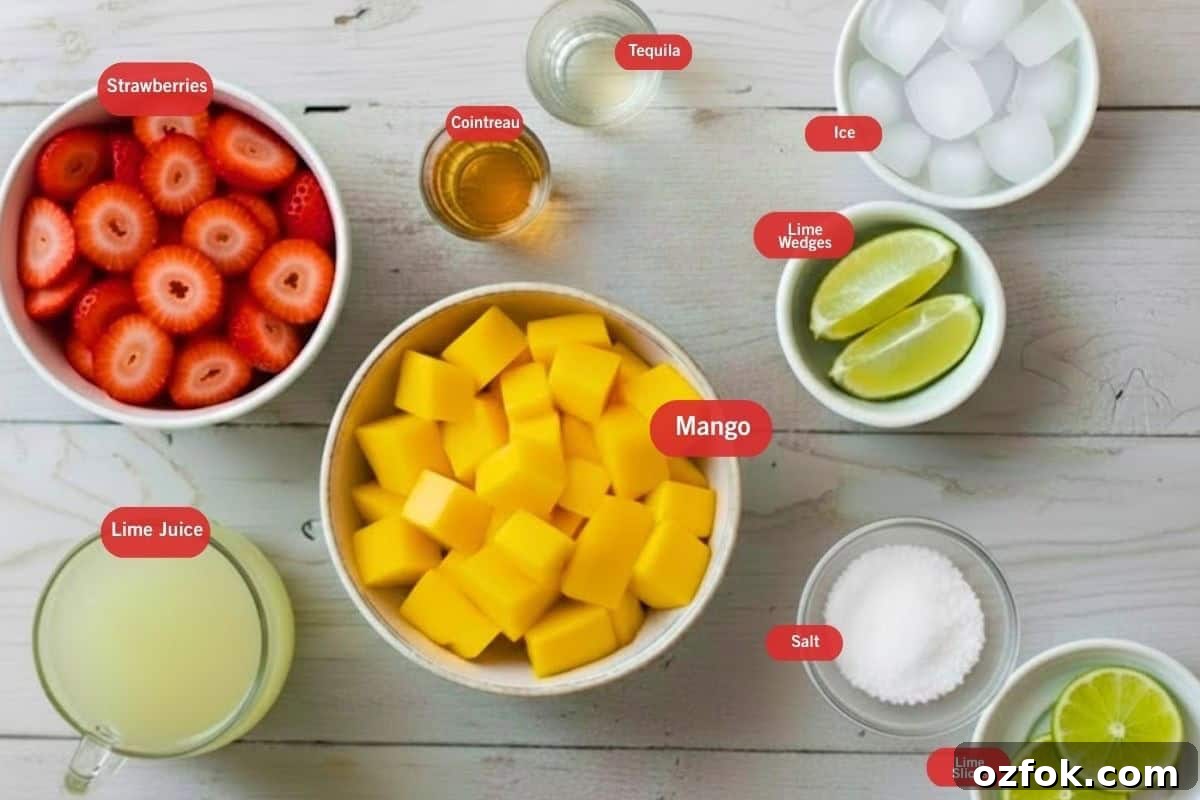 Frozen Strawberry Mango Margarita Recipe | Refreshing Summer Cocktail 3 Flat lay photo of strawberries, tequila, cointreau, ice, lime wedges, mango, salt, lime slices, lime juice