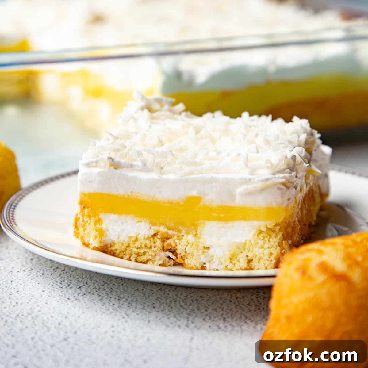 Creamy Twinkie Layer Cake Recipe You’ll Love 2 slice of twinkie cake on a white plate, next to a whole twinkie.