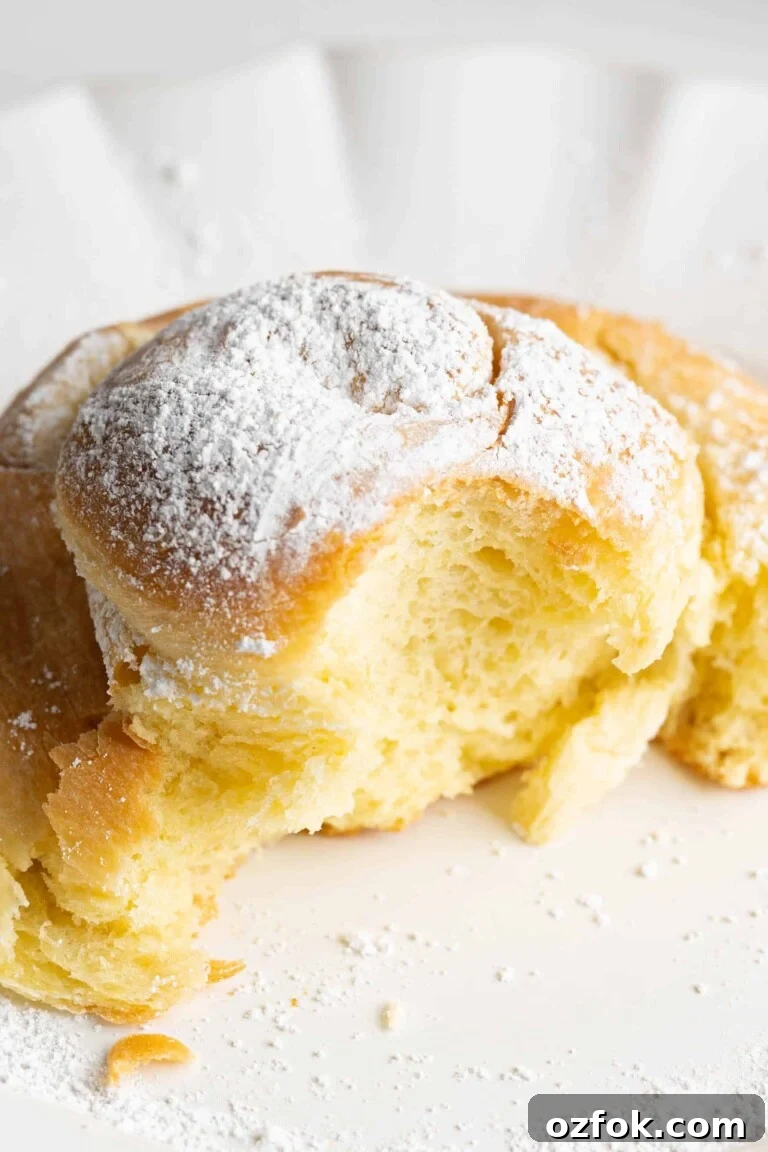 A sweet bun on a plate with a bite taken
