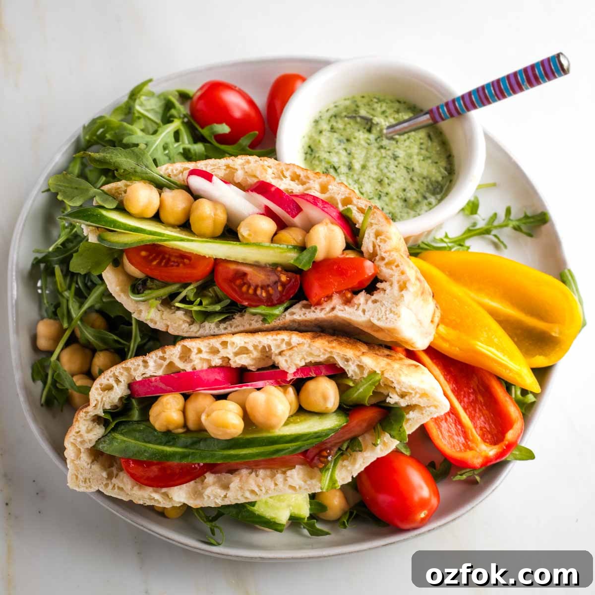 Dairy-Free Tzatziki Sauce: Authentic Vegan Greek Recipe 11 Pita halves filled with fresh vegetables with a side of dairy-free tzatziki sauce.