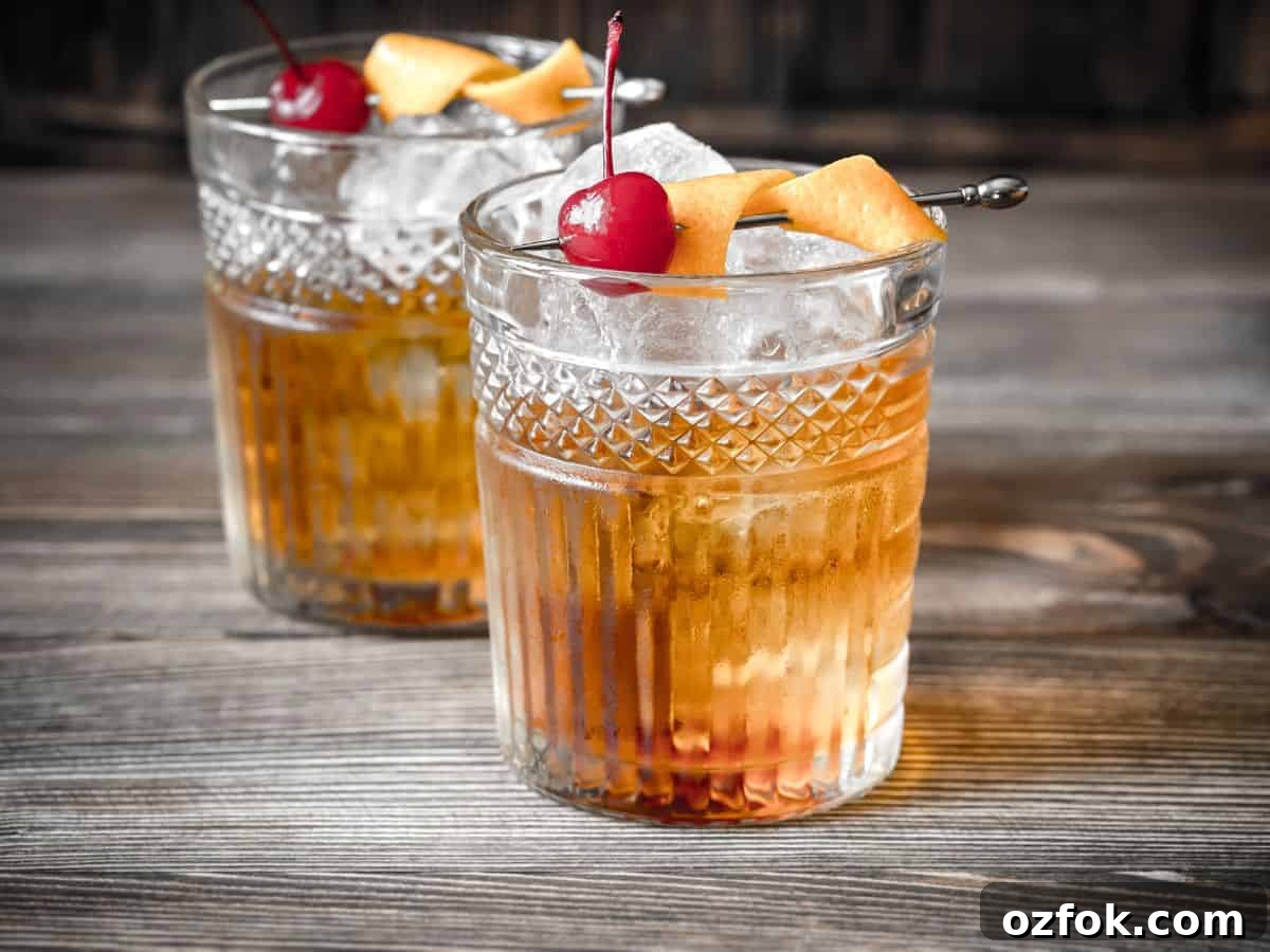 Guide to Cocktail Glasses: Styles, Uses, and Cocktail Pairings 13 Lowball whiskey glass with cherry and orange peel.