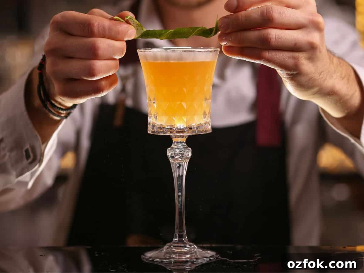 Guide to Cocktail Glasses: Styles, Uses, and Cocktail Pairings 14 A bartender adding a garnish to a cocktail in a sour glass.