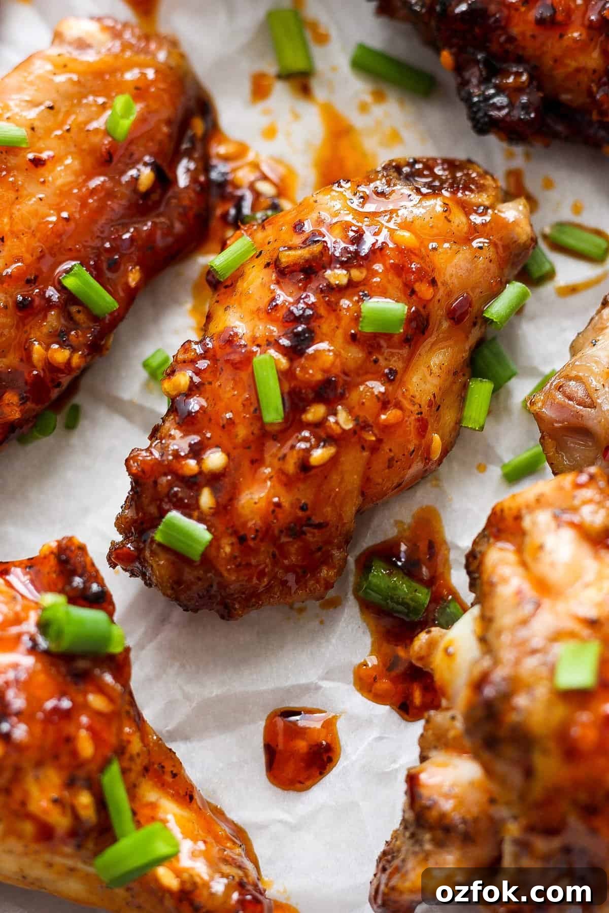 Honey Chili Crisp Grilled Chicken Wings Recipe 6 Glazed chicken wings sprinkled with sesame seeds and chopped green onions.