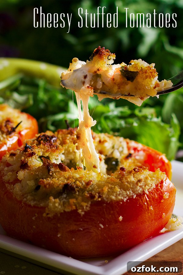 Cheese-Stuffed Tomatoes with Herbed Breadcrumb Topping 2 Someone using a fork to take a bite from a cheesy stuffed tomato.