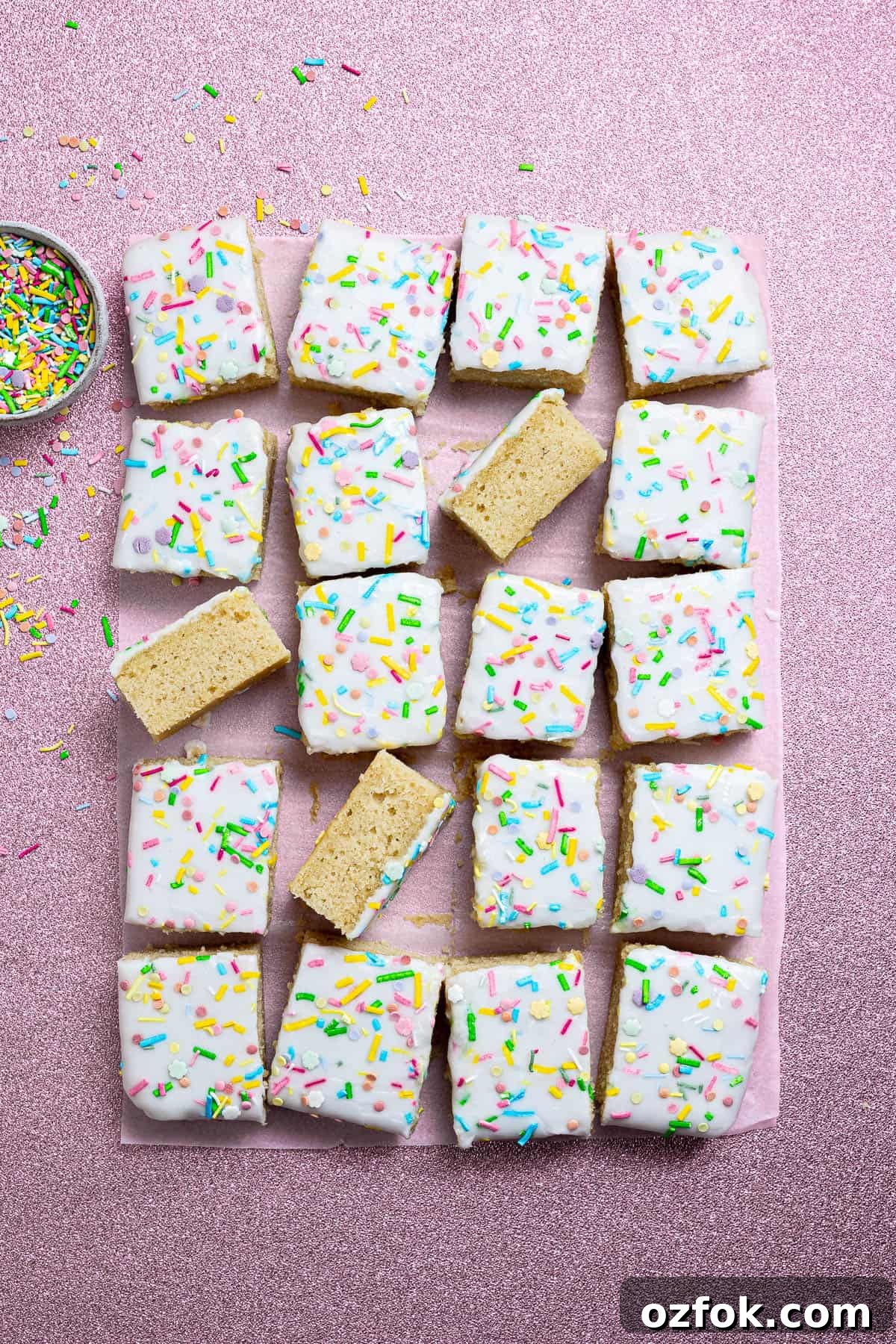 Vegan Birthday Cake Ideas for School Parties 11 Vegan school cake on a pink background with a bowl of sprinkles.