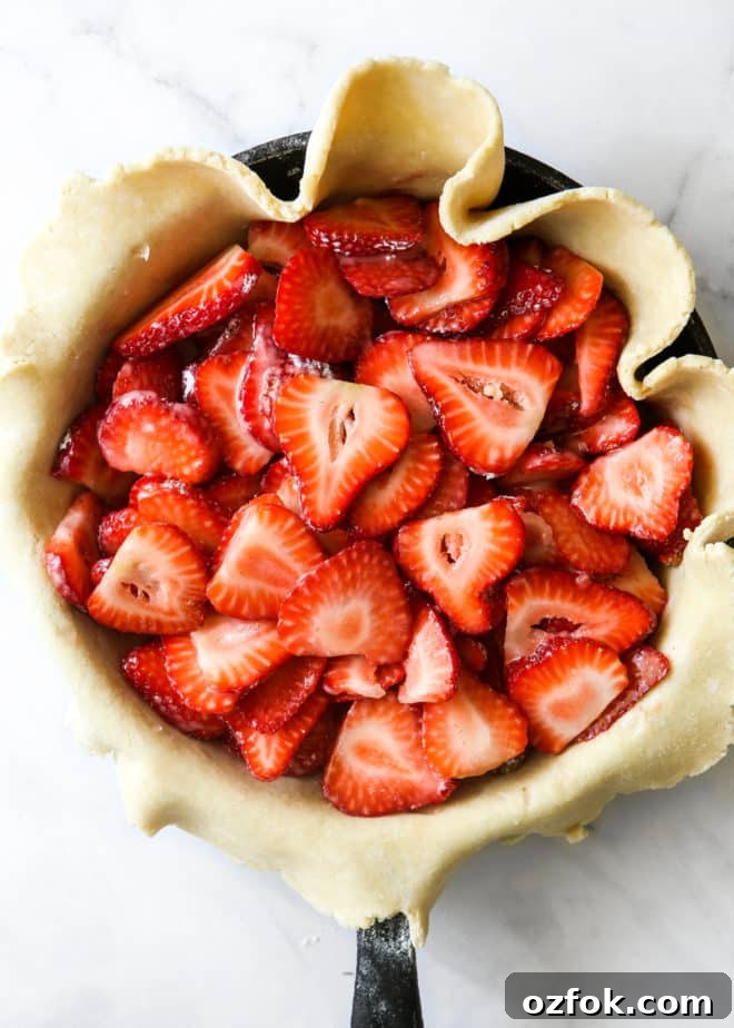 Skillet Strawberry Pie: Sweet, Quick Pan-Baked Dessert 5 sliced strawberries in pie crust inside skillet