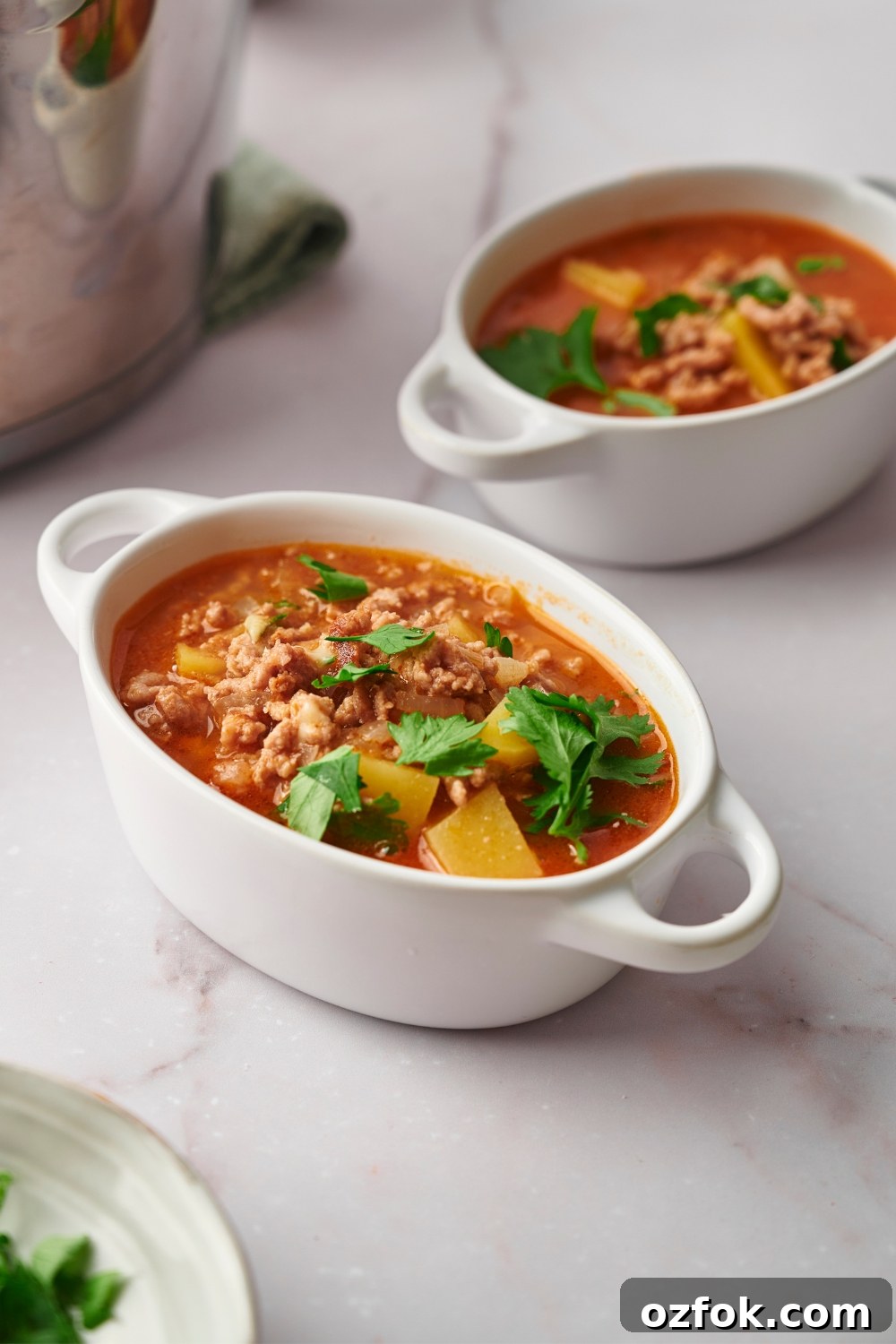 30-Minute Ground Beef and Vegetable Soup Recipe 2 Two bowls of vegetable beef soup on a white counter.