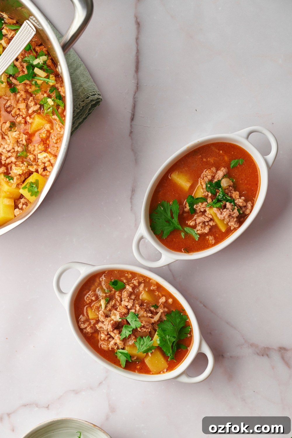 30-Minute Ground Beef and Vegetable Soup Recipe 11 Two bowls of ground beef vegetable soup with part of the pot of soup to the left of it.