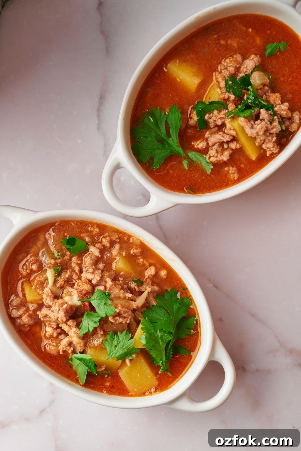 30-Minute Ground Beef and Vegetable Soup Recipe 12 Beef vegetable soup in two bowls on a white counter.