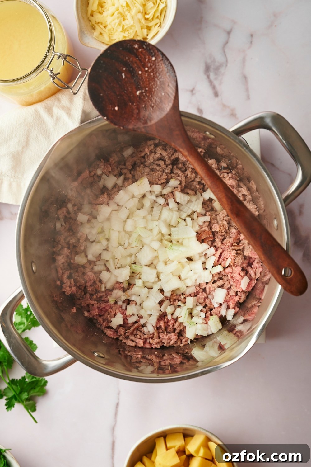 30-Minute Ground Beef and Vegetable Soup Recipe 6 Diced onion on top of ground beef cooking in a large pot.