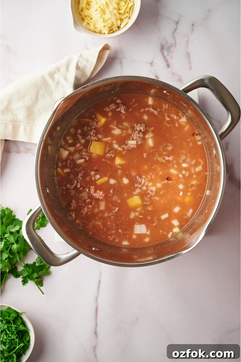30-Minute Ground Beef and Vegetable Soup Recipe 9 A tomato broth with ground beef, potatoes, and onion in it.