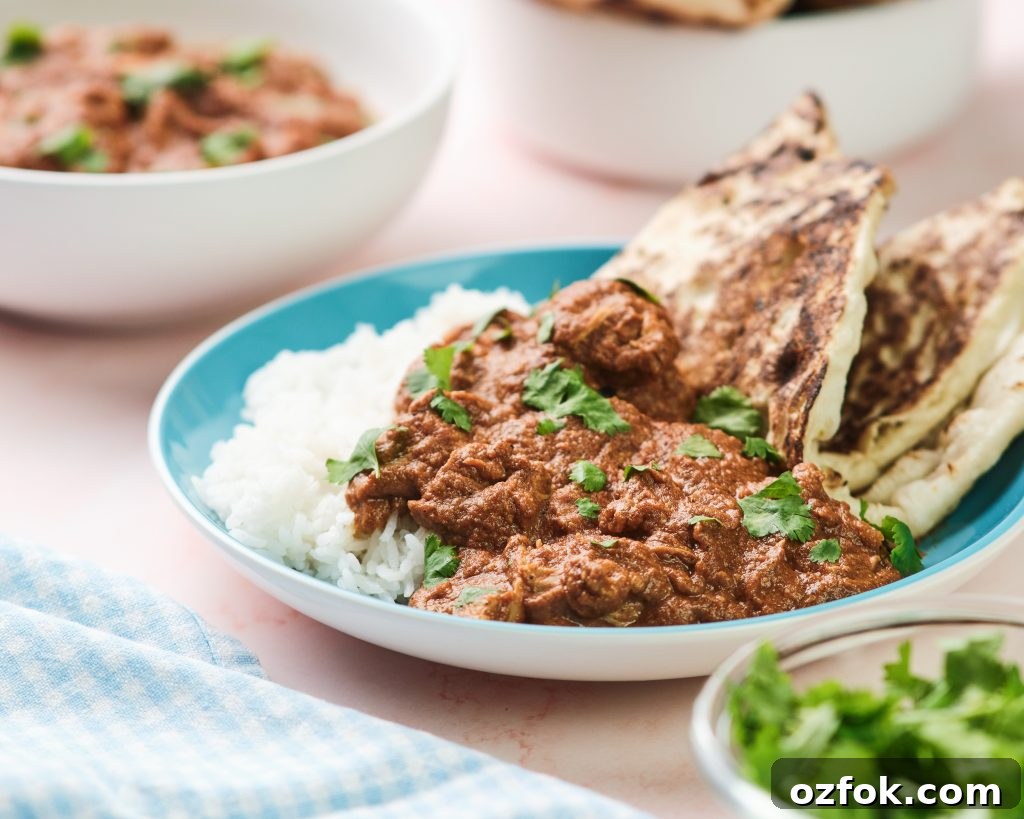 Slow Cooker Chicken Tikka Masala Recipe for Tender, Creamy Curry 2 chicken tikka masala with rice and naan on a blue plate