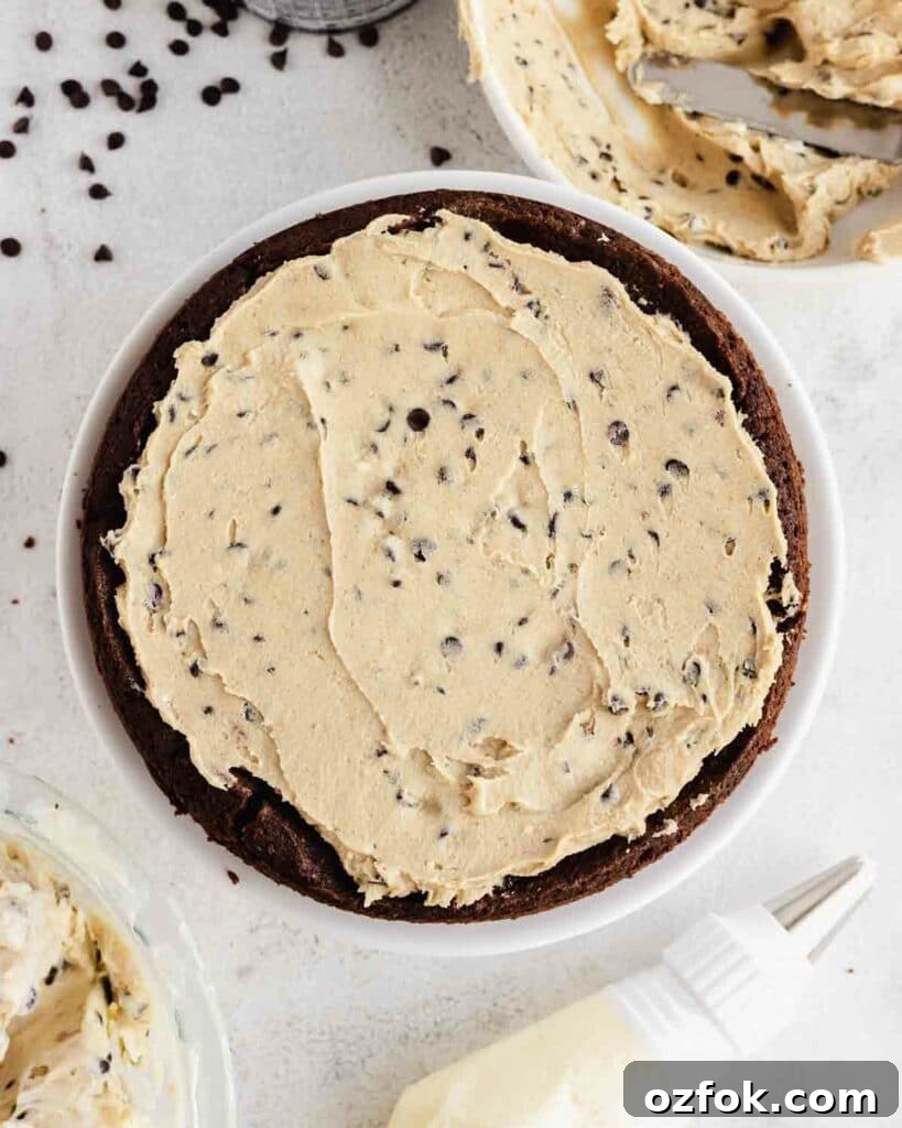 Cookie Dough Fudge Brownie Cake Recipe for Decadent Desserts 11 spreading edible cookie dough on top of brownie layer