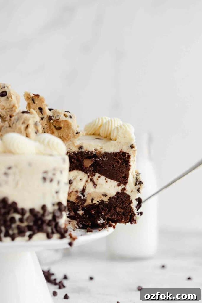 Cookie Dough Fudge Brownie Cake Recipe for Decadent Desserts 3 taking a slice of chocolate cake with layer of cookie dough and cookie dough buttercream