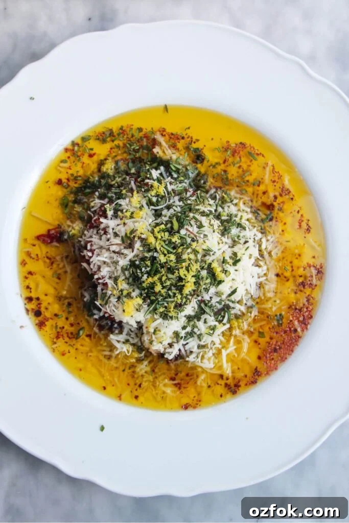 10-Minute Mediterranean Bread Dipping Oil Recipe 4 Ingredients for olive oil dip piled on top of eachother on a large white plate.