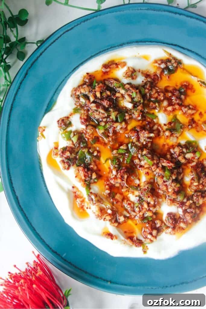 10-Minute Mediterranean Bread Dipping Oil Recipe 9 Sizzling oil on top of creamy Greek yogurt on a teal plate.