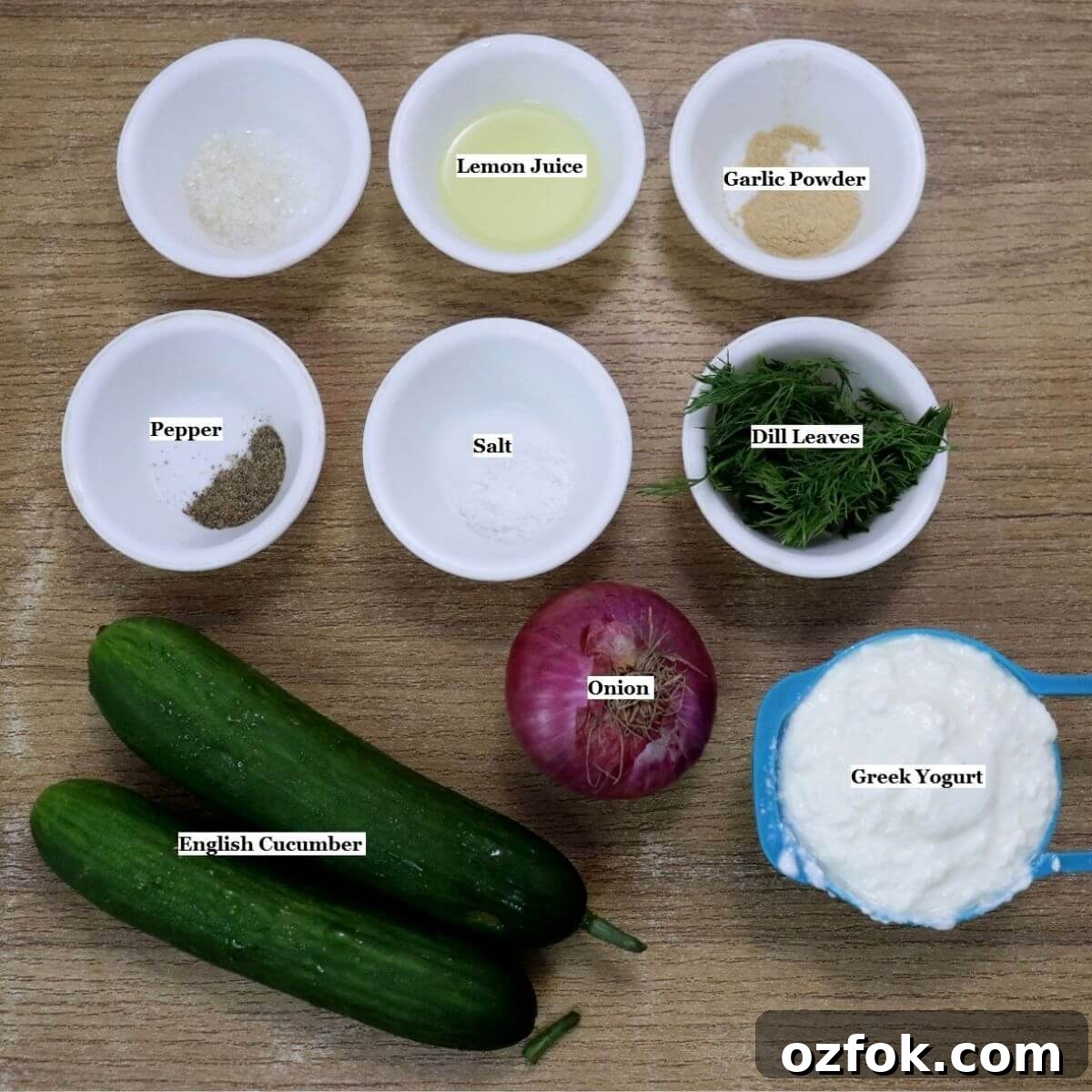 Creamy Greek Yogurt Cucumber Salad with Dill and Lemon 3 individually labeled ingredients to make greek yogurt cucumber salad are laid out on a table.