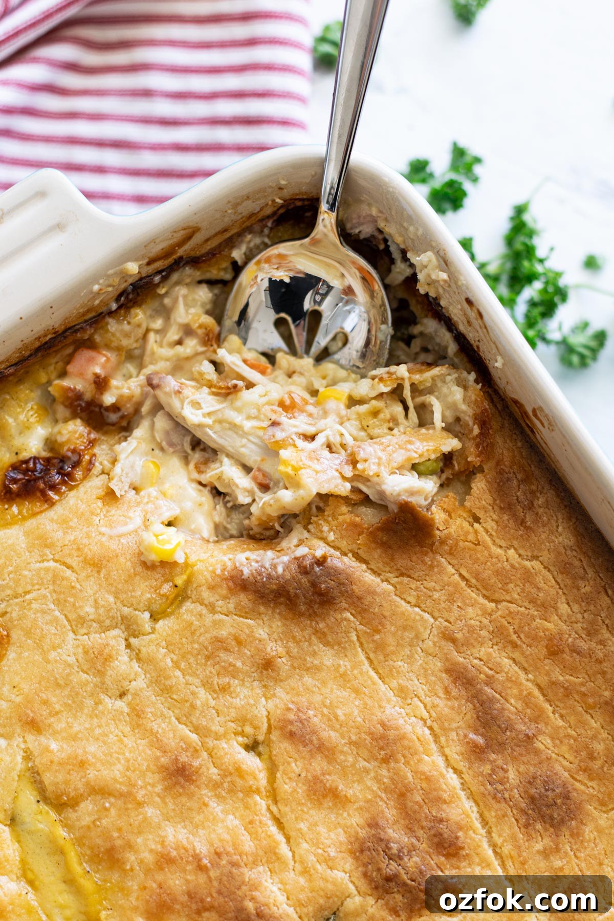 Chicken casserole with spoon in a Pyrex dish.