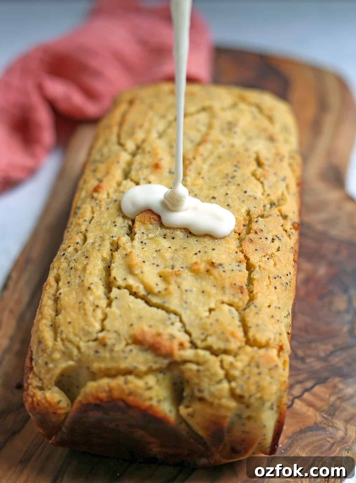 Paleo Lemon Poppy Seed Loaf — Gluten-Free Citrus Bread 4 Glaze being poured over lemon bread.