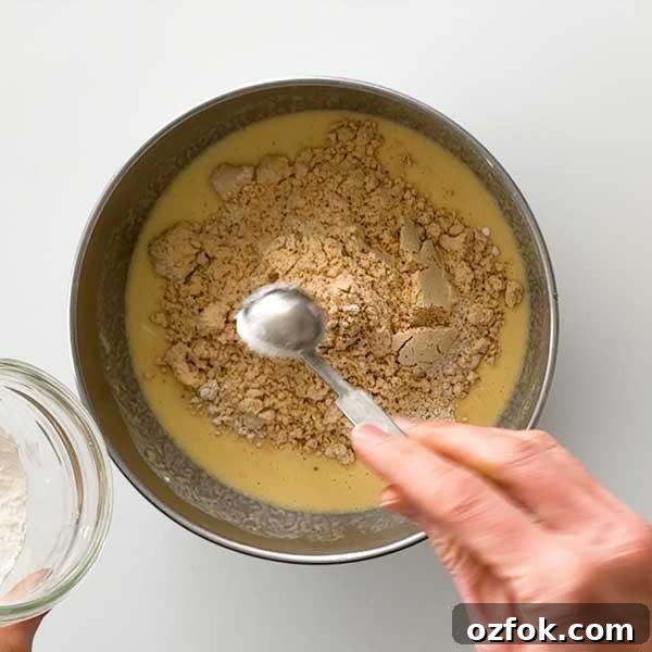 Fluffy Gluten-Free Oat Flour Protein Pancakes 5 Adding the dry ingredients to the pancake batter and a mixing bowl.