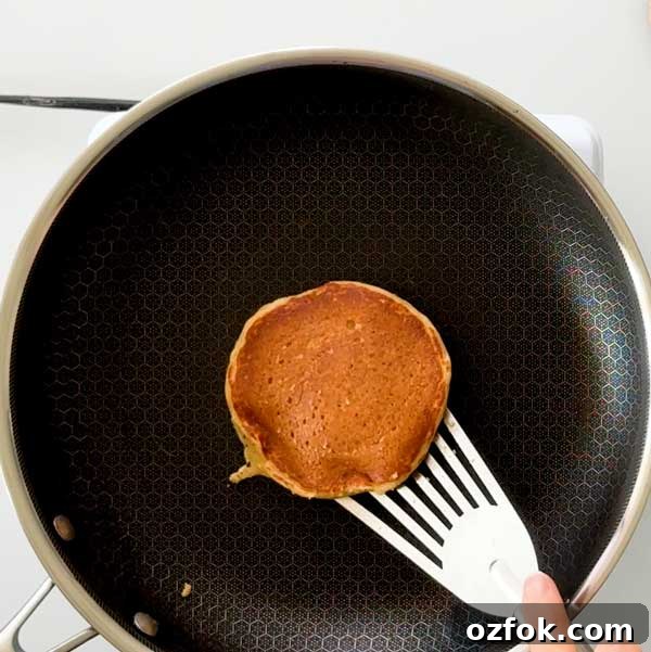 Fluffy Gluten-Free Oat Flour Protein Pancakes 8 Flipping the pancake over in the skillet with a spatula.